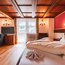 Gemütliches Hotelzimmer mit Holzbalkendecke und großem Bett